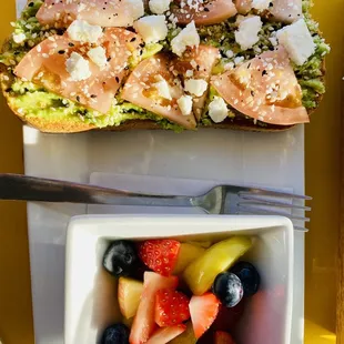 a bowl of fruit and a sandwich