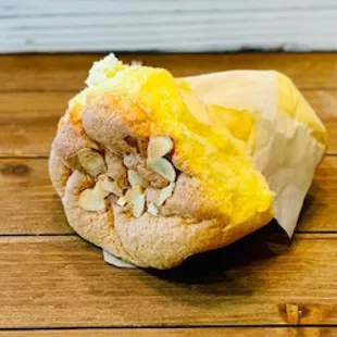 a half eaten sandwich on a wooden table