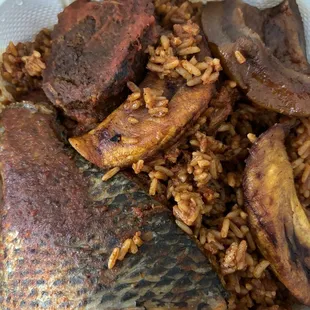 Jollof rice w/ beef, tilapia, cow skin, and plantain
