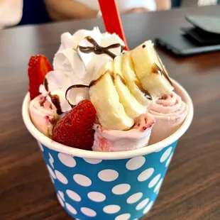 a cup of ice cream with strawberries and bananas