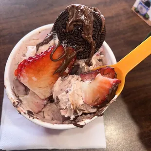 a bowl of ice cream with chocolate covered strawberries