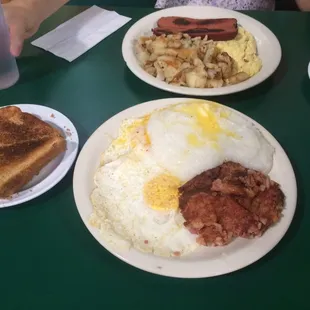 Perfectly cooked eggs over medium with corned beef hash. And those grits!! Yum!