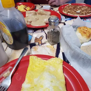 Sausage and cheese omlette, biscuits and gravy, and a pancake .