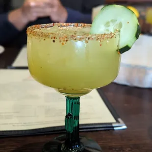 a margarita with a cucumber garnish