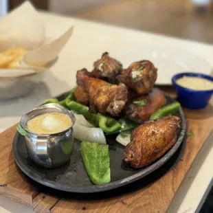 a plate of chicken wings with dipping sauce