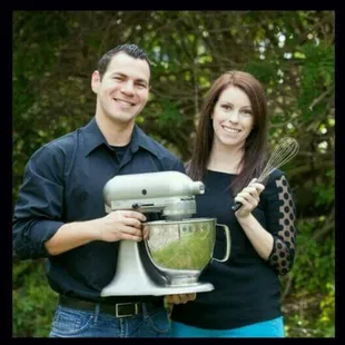 a man and woman holding a mixer