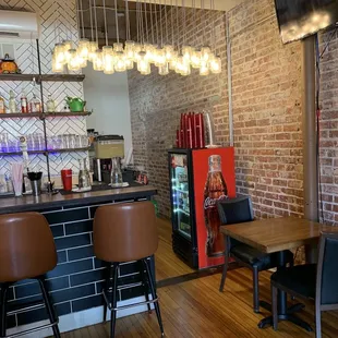 a bar with chairs and a television