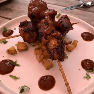 skewered meat on a white plate
