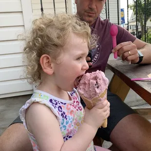 a little girl eating an ice cream cone