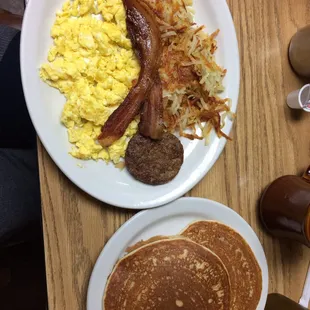 a breakfast of pancakes, eggs, sausage and hash browns