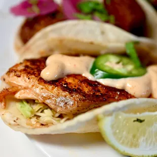 a fish taco with a lime wedge