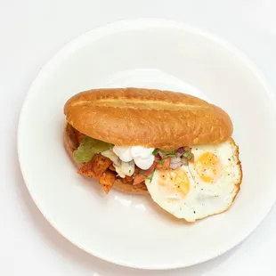 Torta De Chilaquiles! Stuffed with red chilaquiles, eggs, refried beans, tomatoes, onions, cilantro, queso fresco, avocado !