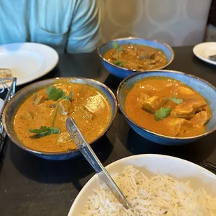 a man sitting at a table with bowls of food