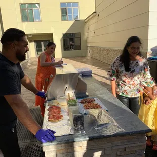Chef Deep onsite taking personal naan pizza toppings orders from the kids at a kids birthday party in Cupertino, CA.  The kids love him!