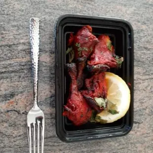 Hard and dry Tandoori Chicken - NOT EVEN EDIBLE! Look how big the lemon is as compared to the chicken...