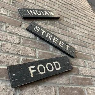  street signs on brick wall