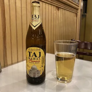 a glass of beer and a bottle on a table
