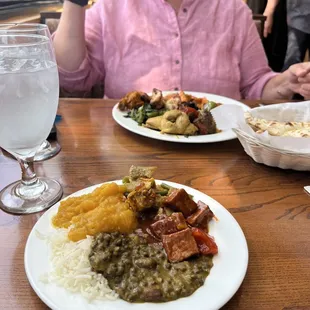 a woman sitting at a table with plates of food