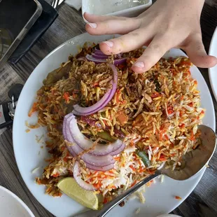 a plate of rice with onions and onions