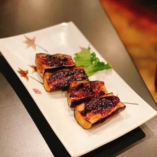 four pieces of meat on a white plate