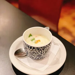 a bowl of soup on a plate with a spoon