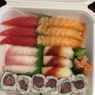 a variety of sushi in a styrofoam container