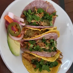 three tacos on a white plate