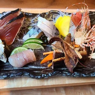 Sashimi assortment including sweet shrimp, oyster, trout, king Salmon,  and Norwegian Mackerel