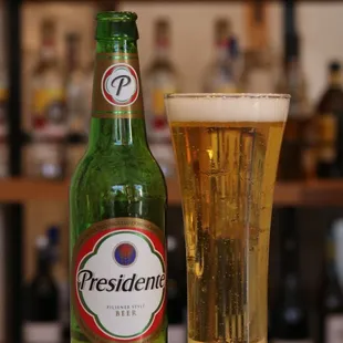  a bottle of president beer and a glass of beer