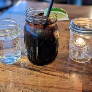 Water, Diet Coke, and a candle in mason jars
