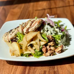 Roasted Pear Salad with grilled chicken, mixed greens, house-roasted spiced nuts, red onion, blue cheese, house-made balsamic vinaigrette.
