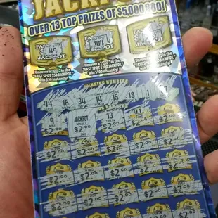 a hand holding a $ 5 million jackpot
