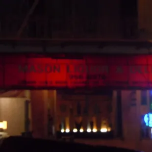 a neon sign for mason liquor and deli