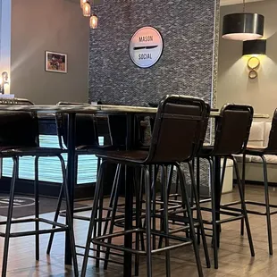 a bar with stools and a clock on the wall