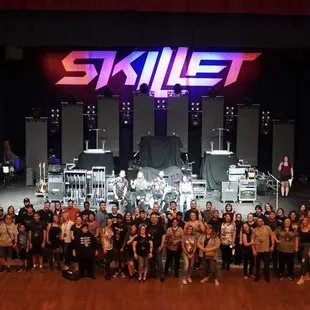 a large group of people standing in front of a stage