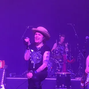 a man in a cowboy hat singing into a microphone