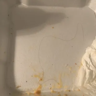 a piece of food left in a styrofoam container