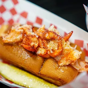 a lobster roll with a pickle
