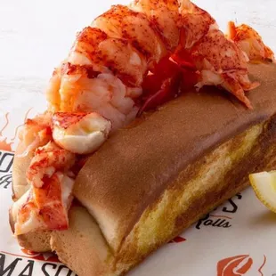 a lobster roll with a slice of lemon