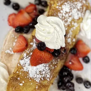 a plate of french toast with strawberries and blueberries