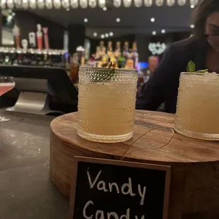 two cocktails on a wooden stand