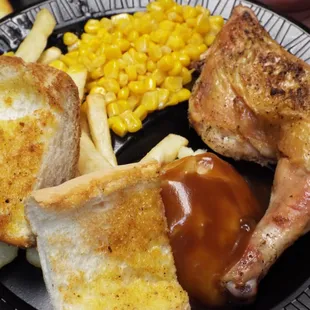 a plate of food with chicken, french fries and corn
