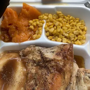 a tray of food including chicken, corn, and bread