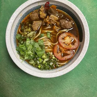 a bowl of soup with meat and vegetables