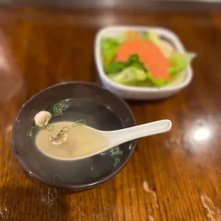 a close up of a bowl of soup and a bowl of salad