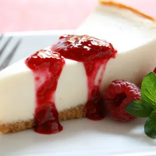 a slice of cheesecake with raspberry sauce