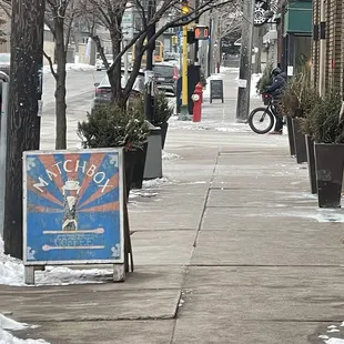 Sidewalk in front of the store/ sign for coffee shop