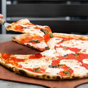 a person cutting a pizza