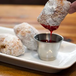 a person dipping a donut into a cup