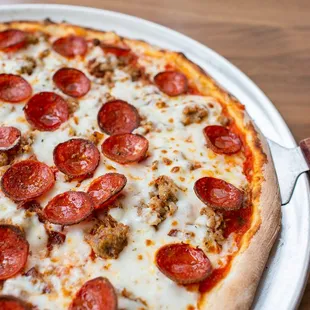 a pepperoni pizza on a pizza pan